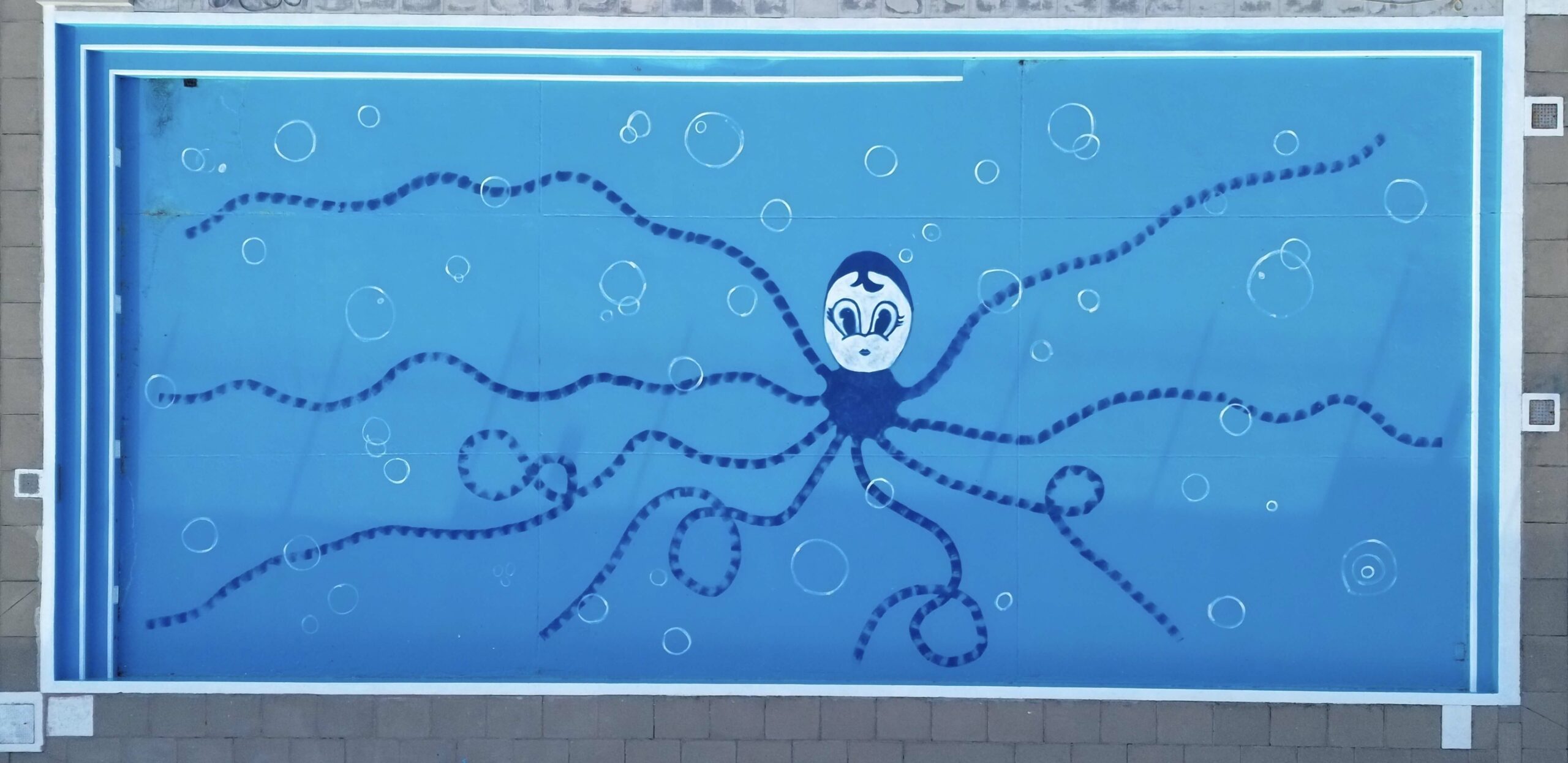 painting of an octopus on bottom of swimming pool