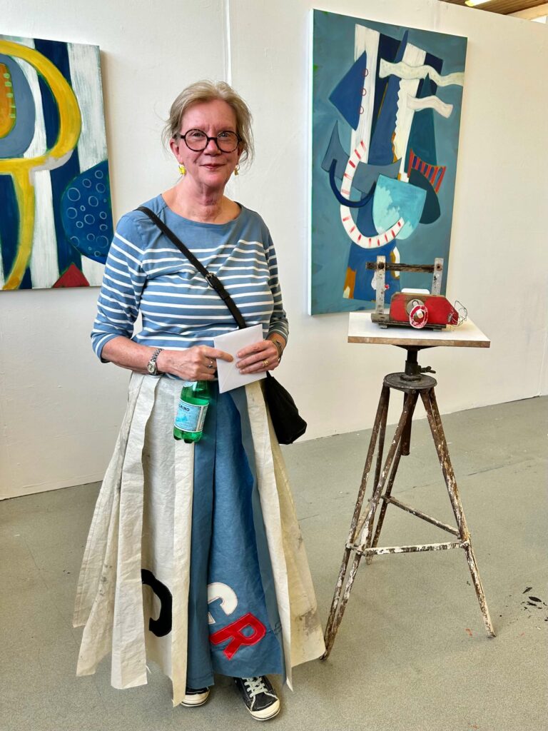 Chrissie Richards female artist in front of paintings